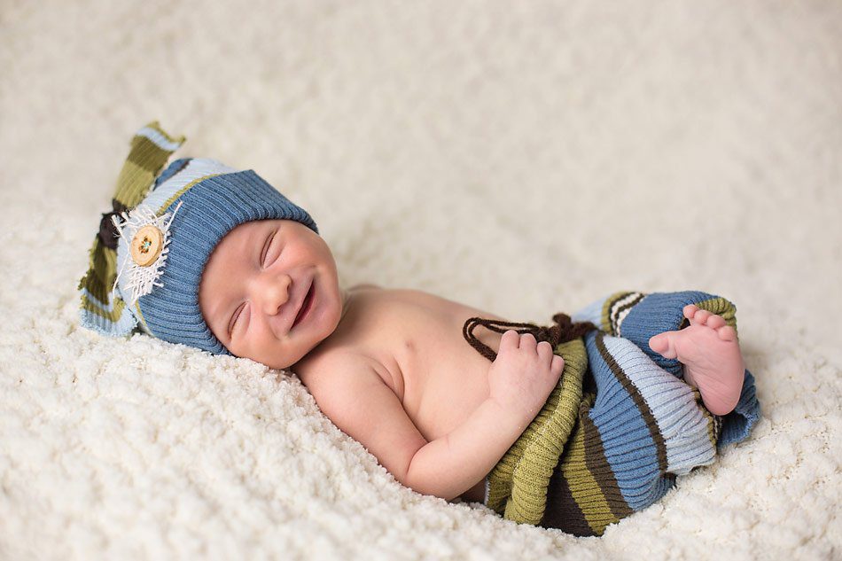 Smiling newborn baby boy by Pueblo Newborn photographer K.D. Elise Photography.