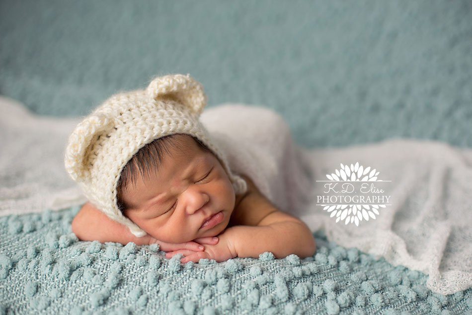 Newborn in a bear bonnet, sleeping peacefully on a blue blanket. Newborn photography by Colorado Springs newborn photographer K.D. Elise Photography.