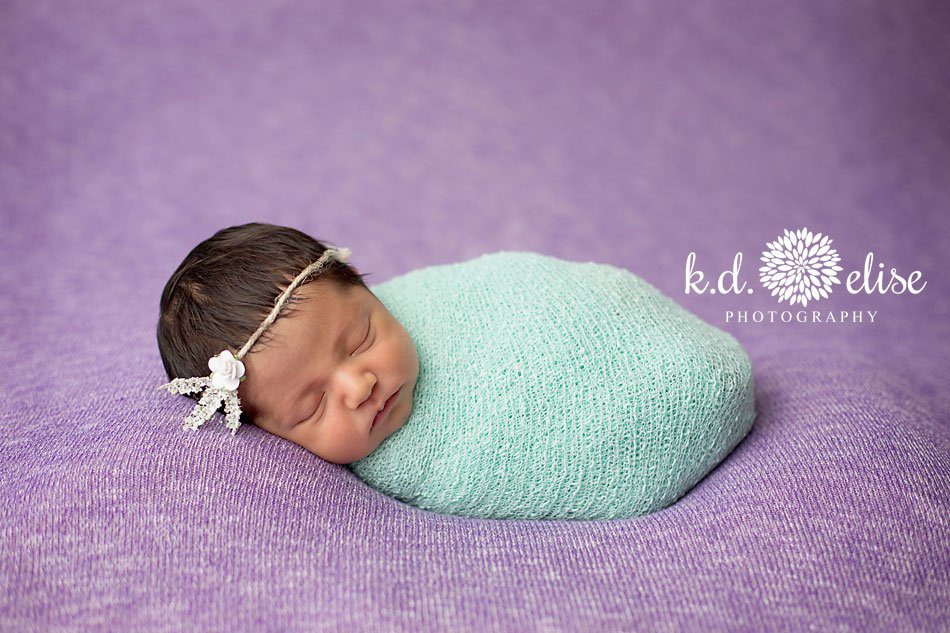 Baby girl in purple and green by Colorado Springs newborn photographer K.D. Elise Photography.