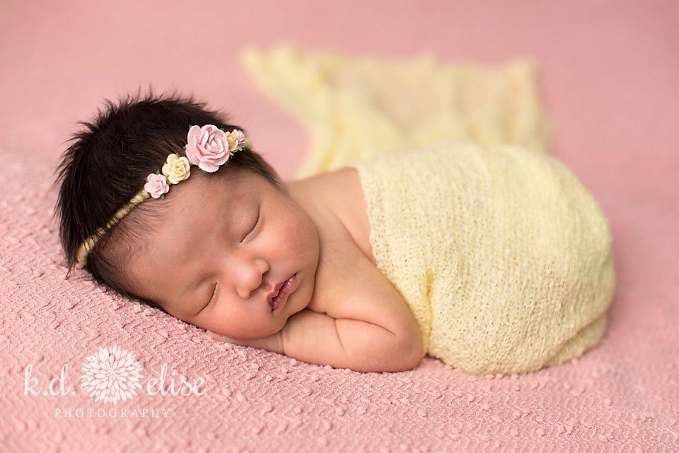 Newborn baby girl in pink and yellow by Pueblo newborn photographer K.D. Elise Photography.