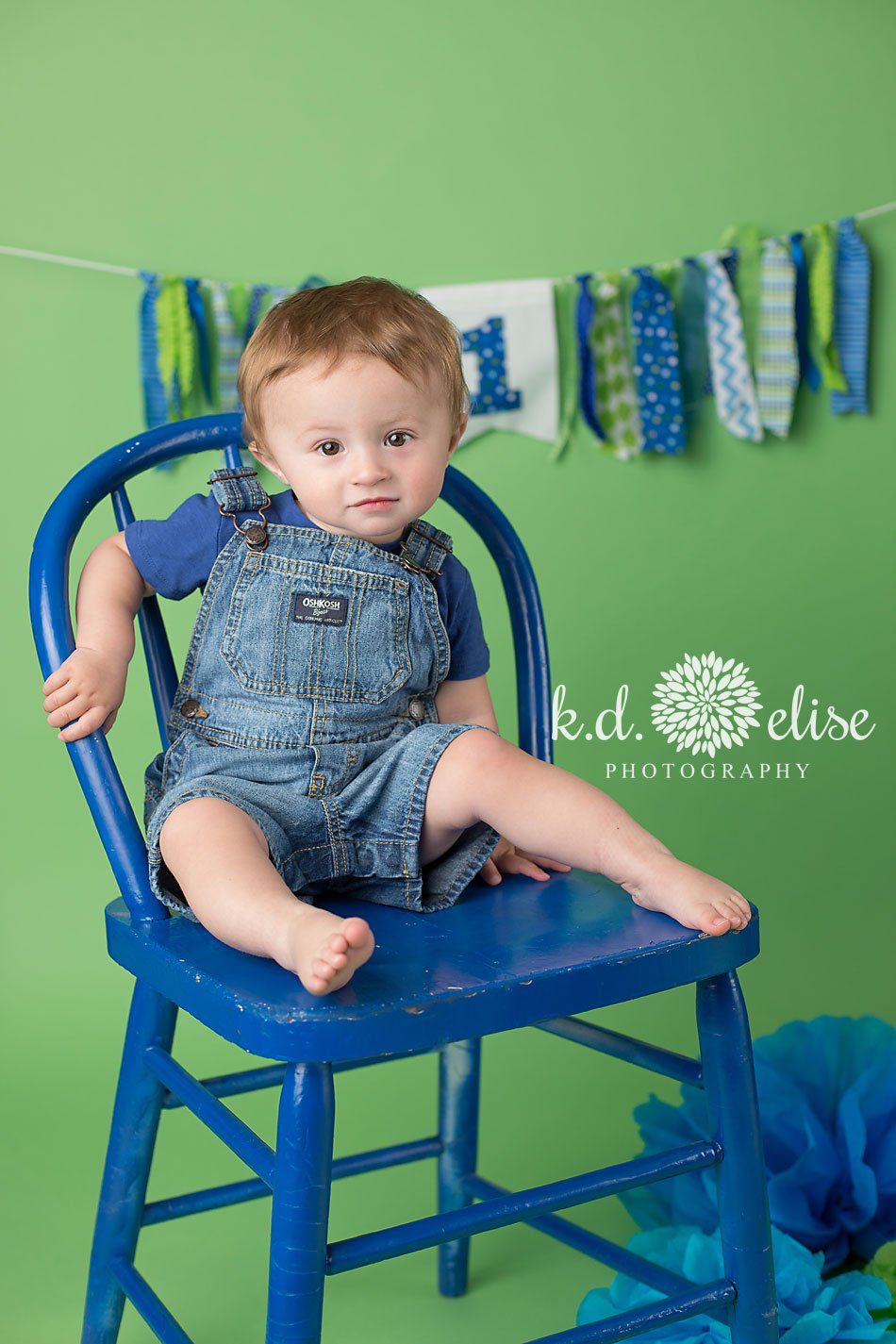 One year old celebrates his first birthday with blue and green themed birthday portraits from Pueblo cake smash photographer K.D. Elise Photography.