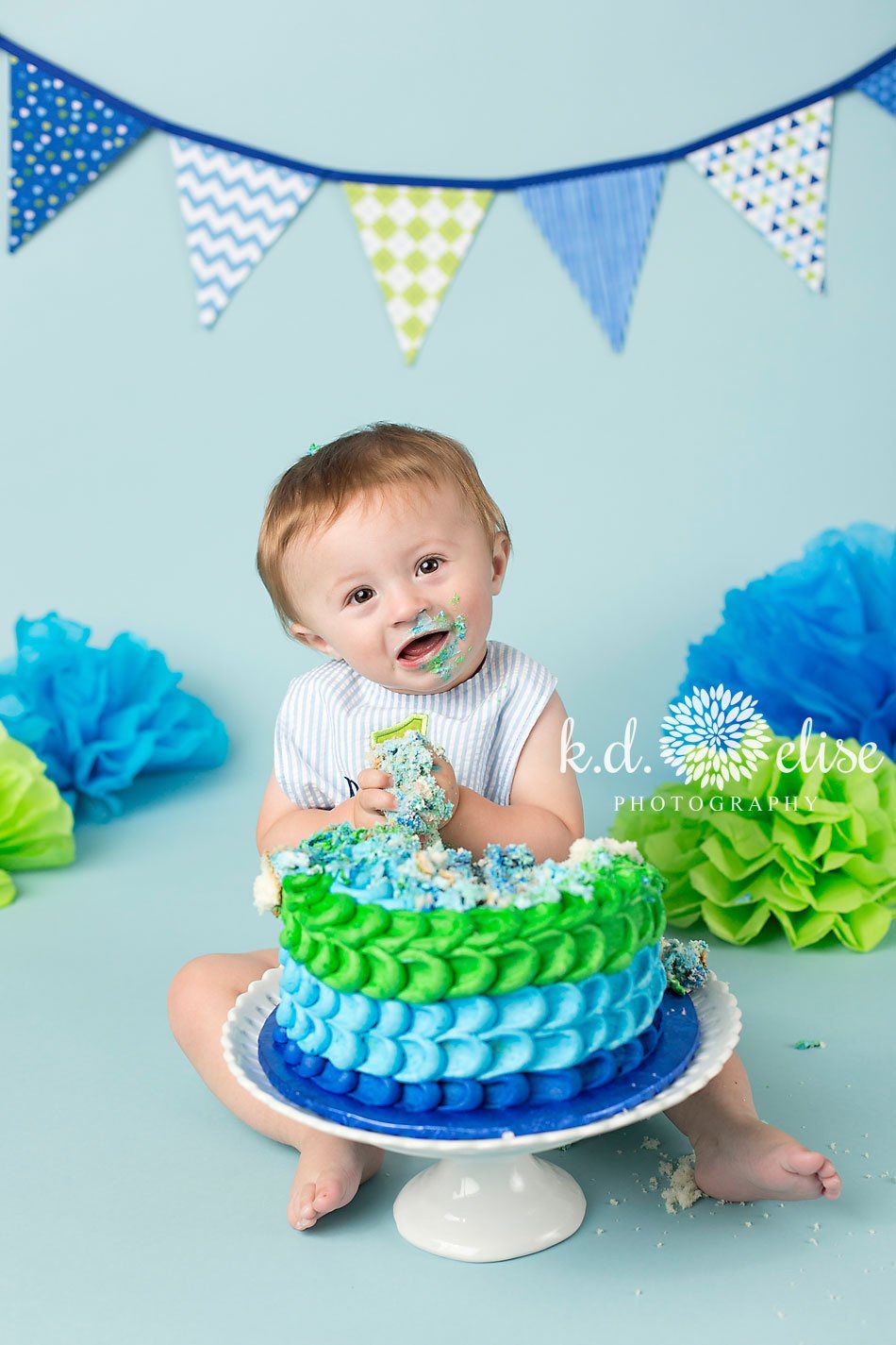 Messy blue and green themed one year old boy's cake smash session by Pueblo photographer K.D. Elise Photography.