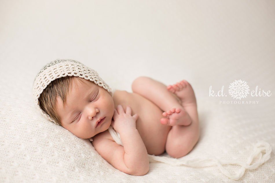 Baby girl in cream bonnet, newborn photography by K.D. Elise Photography.