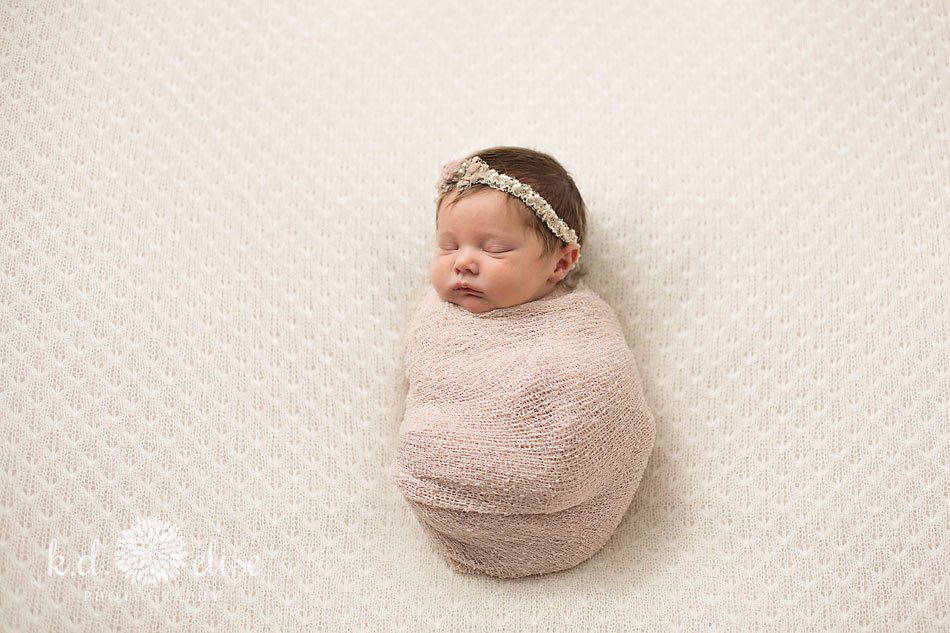 Newborn baby girl in pink wrap by Colorado Springs newborn photographer K.D. Elise Photography