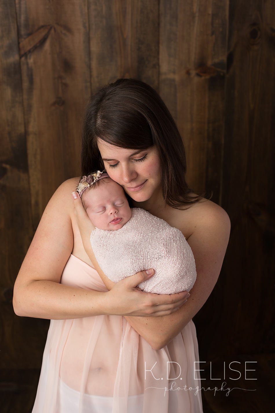 Newborn baby girl being held in her mama's arms. Newborn baby and mama portrait by Pueblo photographer K.D. Elise Photography.