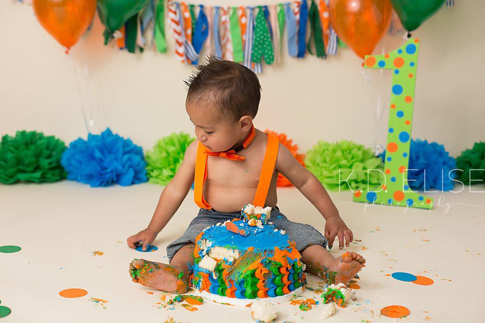 One year old boy playing with cake during cake smash session with Pueblo photographer K.D. Elise Photography.
