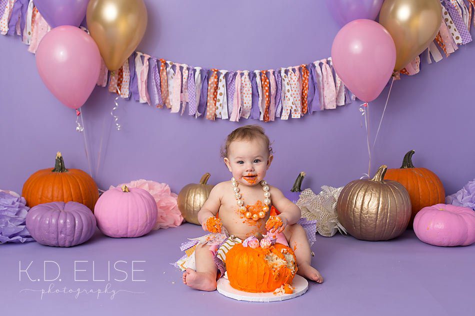 Pumpkin themed pink, gold, orange and purple first birthday cake smash photos by Pueblo cake smash photographer K.D. Elise Photography