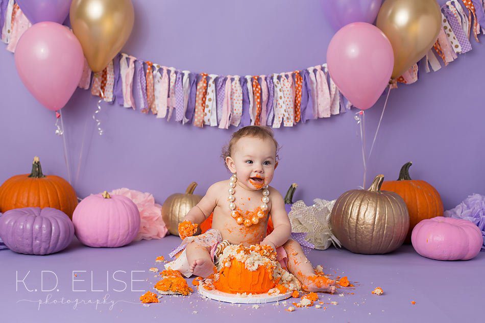Baby girl's pumpkin themed cake smash photo shoot by Pueblo photographer K.D. Elise Photography.