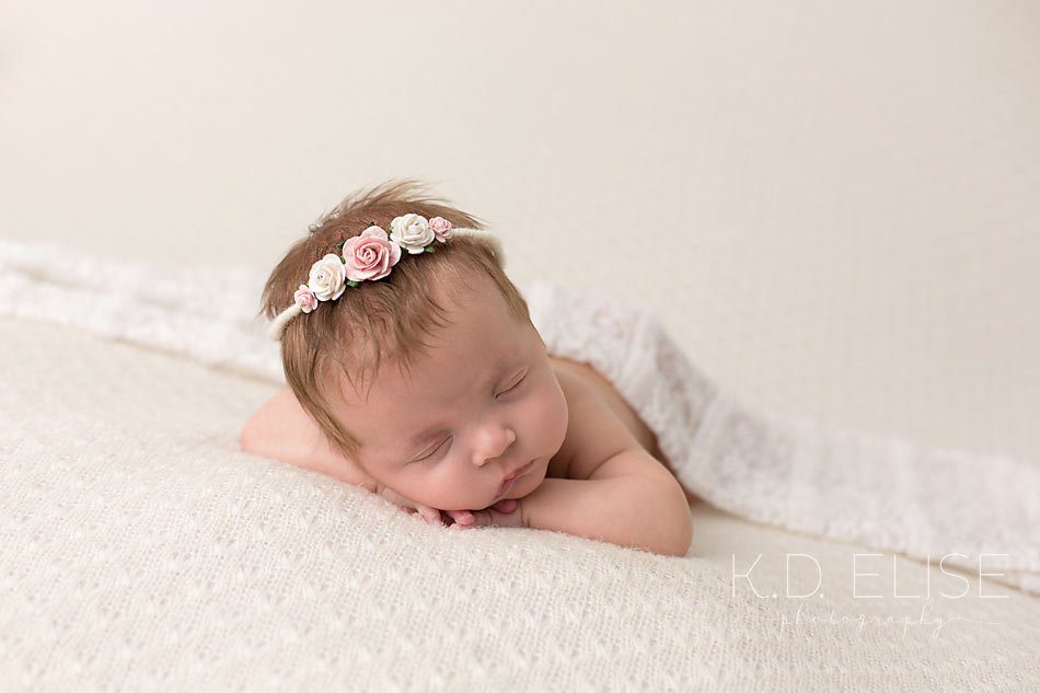 Newborn girl laying with her head on her hands. Newborn portrait by Colorado Springs newborn photographer K.D. Elise Photography.