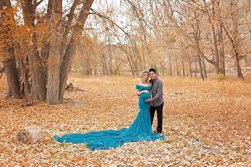 Pregnant mom and her husband, posing with hands on her belly during maternity session with Pueblo maternity photographer K.D. Elise Photography.