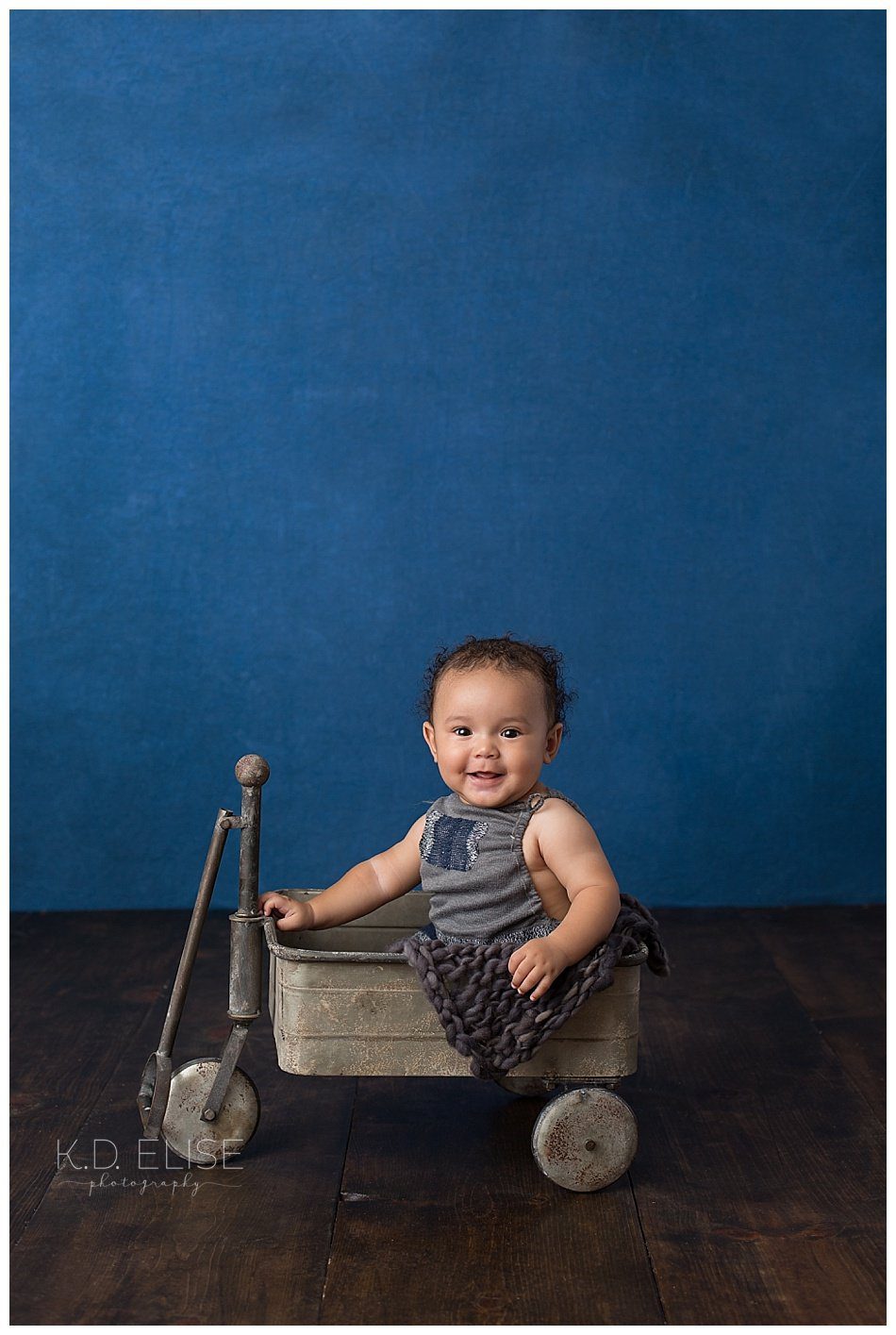 Six month baby photos of little boy in a metal wagon.