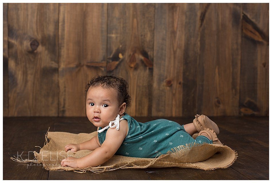 Six month baby photos of little boy laying on his tummy.