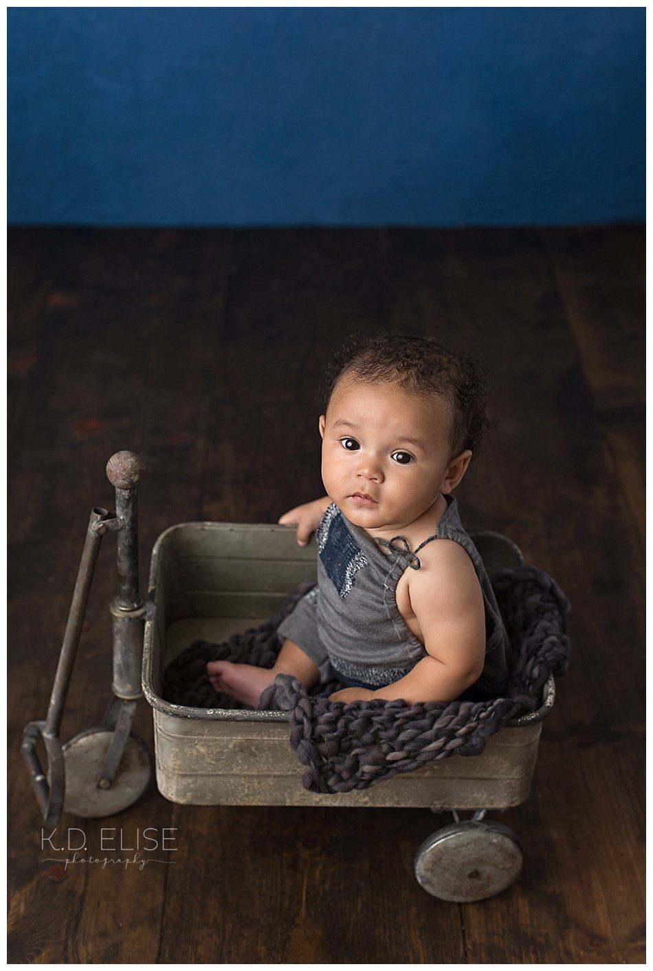 Six month old baby boy in a metal wagon.