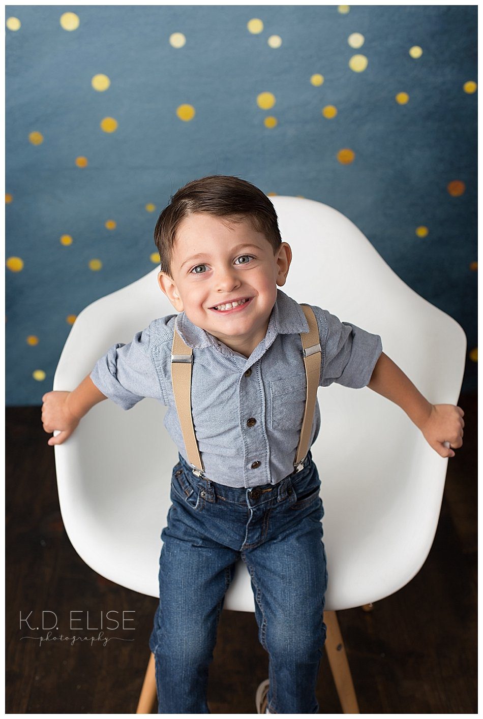 Smiling little boy looks at the camera during his three year birthday portraits.