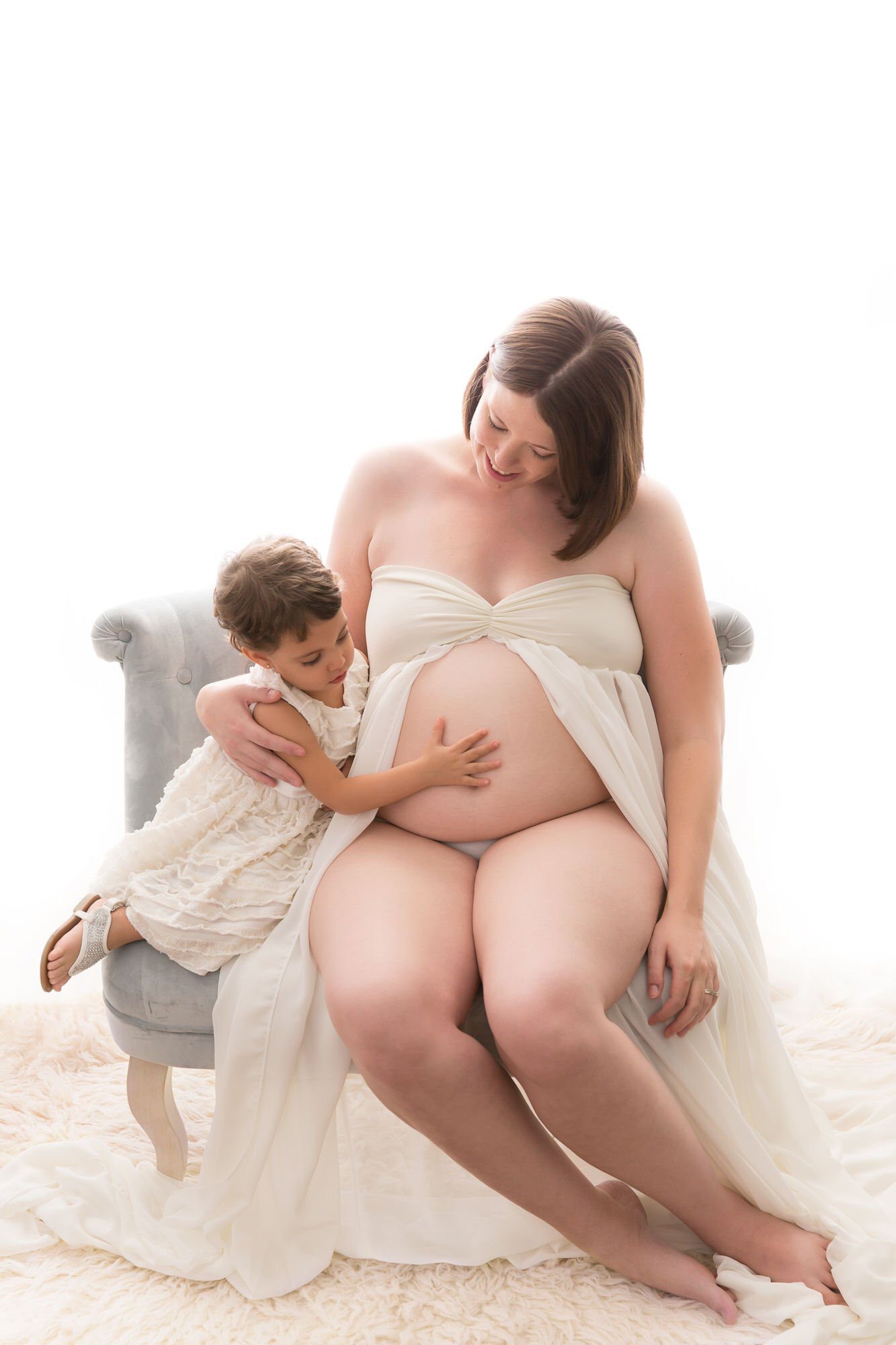 Little girl touching her pregnant mom's belly during maternity session with Pueblo-Colorado-Springs maternity photographer K.D. Elise Photography.