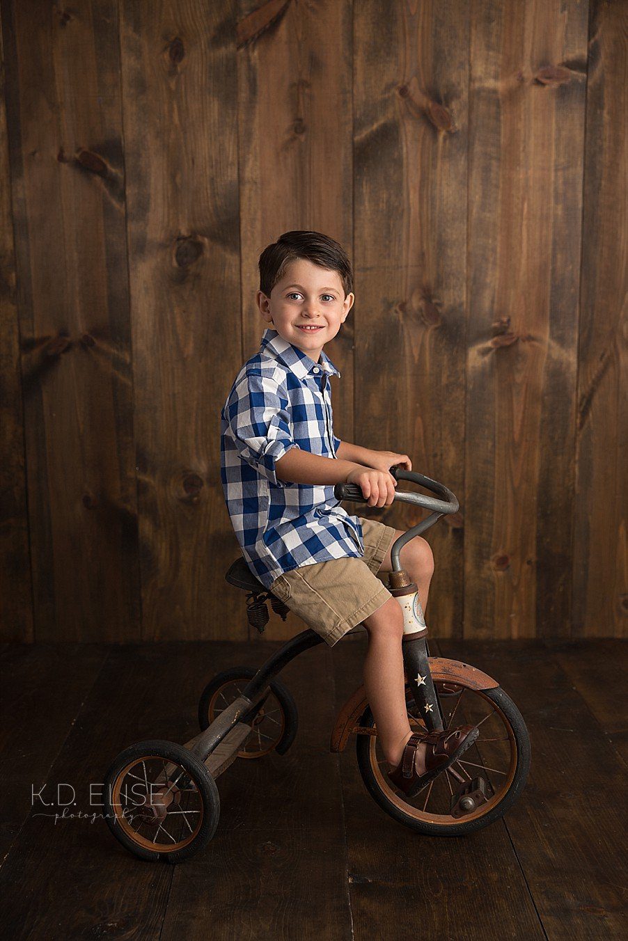 Four year old boy riding a vintage tricycle. 