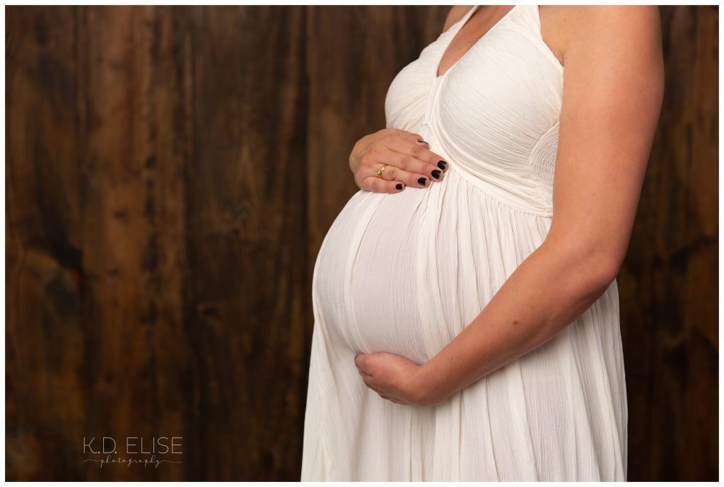 In studio maternity photography portrait of pregnant belly.