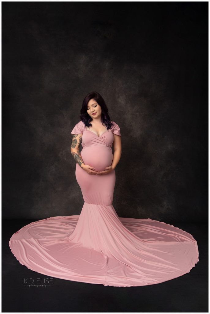 In studio maternity photography, pregnant mom in pink gown.